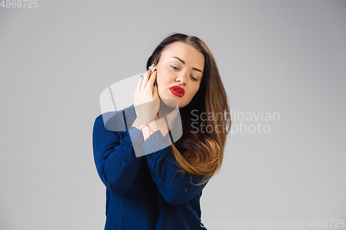 Image of Young woman suffers from pain, feels sick, ill and weakness isolted on studio background