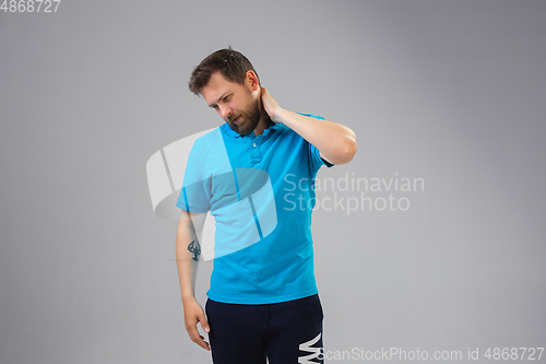 Image of Young man suffers from pain, feels sick, ill and weakness isolted on studio background