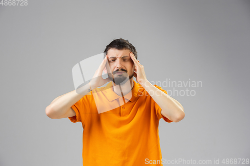 Image of Young man suffers from pain, feels sick, ill and weakness isolted on studio background