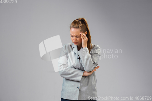 Image of Young woman suffers from pain, feels sick, ill and weakness isolted on studio background