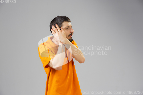 Image of Young man suffers from pain, feels sick, ill and weakness isolted on studio background