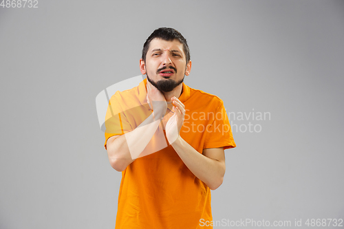 Image of Young man suffers from pain, feels sick, ill and weakness isolted on studio background