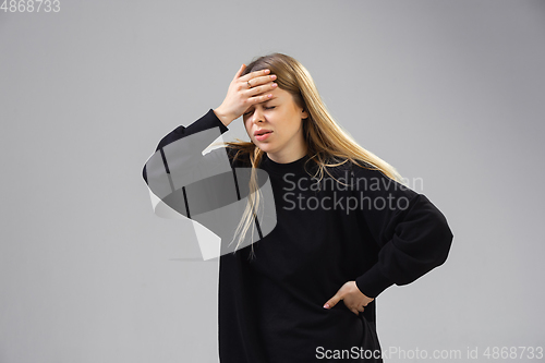 Image of Young woman suffers from pain, feels sick, ill and weakness isolted on studio background