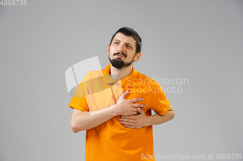 Image of Young man suffers from pain, feels sick, ill and weakness isolted on studio background