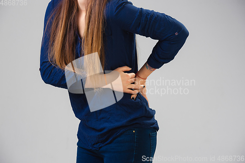 Image of Young woman suffers from pain, feels sick, ill and weakness isolted on studio background