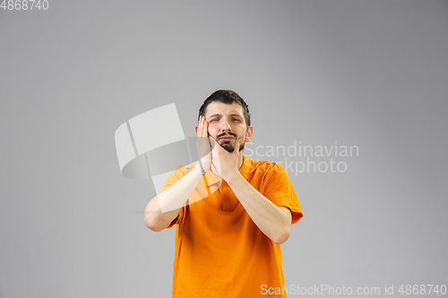 Image of Young man suffers from pain, feels sick, ill and weakness isolted on studio background