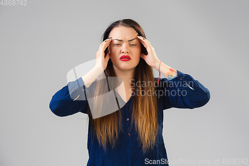 Image of Young woman suffers from pain, feels sick, ill and weakness isolted on studio background