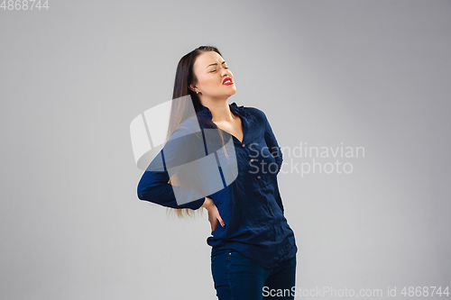 Image of Young woman suffers from pain, feels sick, ill and weakness isolted on studio background