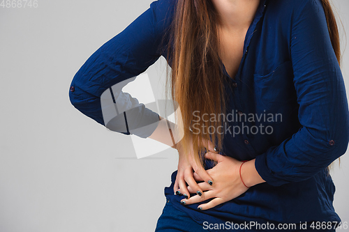 Image of Young woman suffers from pain, feels sick, ill and weakness isolted on studio background