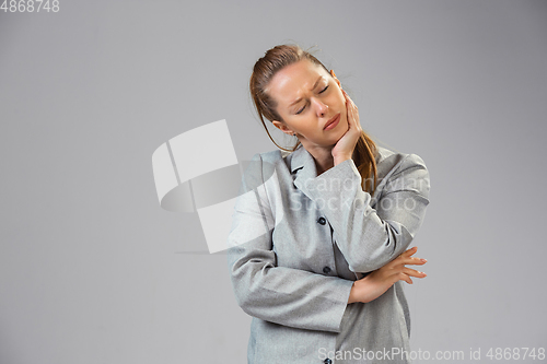 Image of Young woman suffers from pain, feels sick, ill and weakness isolted on studio background