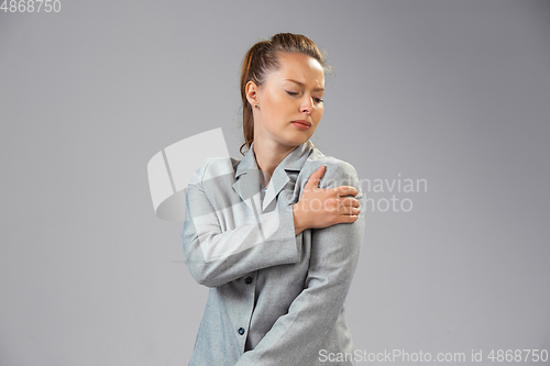 Image of Young woman suffers from pain, feels sick, ill and weakness isolted on studio background