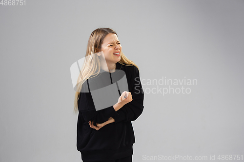 Image of Young woman suffers from pain, feels sick, ill and weakness isolted on studio background