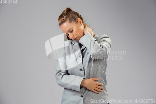 Image of Young woman suffers from pain, feels sick, ill and weakness isolted on studio background