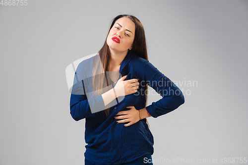 Image of Young woman suffers from pain, feels sick, ill and weakness isolted on studio background