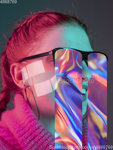 Image of Modern woman\'s portrait on studio background in bright neon light, stylish creative design