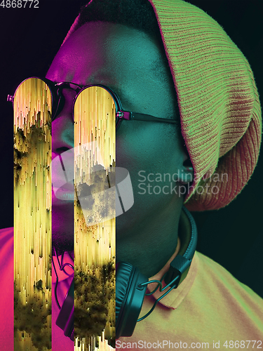 Image of Modern man\'s portrait on studio background in bright neon light, stylish creative design