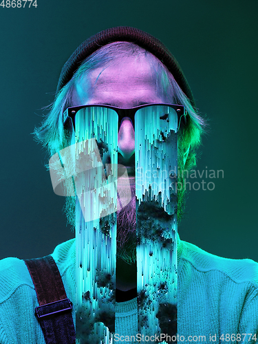 Image of Modern man\'s portrait on studio background in bright neon light, stylish creative design