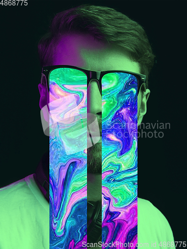 Image of Modern man\'s portrait on studio background in bright neon light, stylish creative design