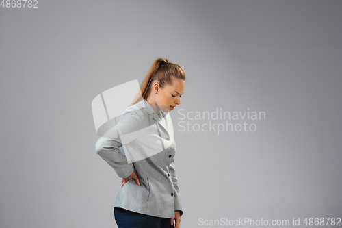 Image of Young woman suffers from pain, feels sick, ill and weakness isolted on studio background