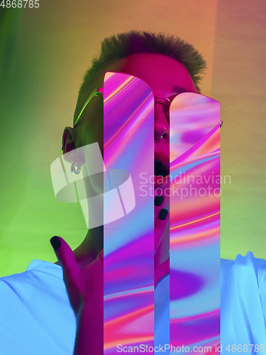 Image of Modern woman\'s portrait on studio background in bright neon light, stylish creative design