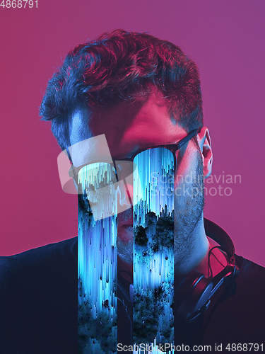 Image of Modern man\'s portrait on studio background in bright neon light, stylish creative design