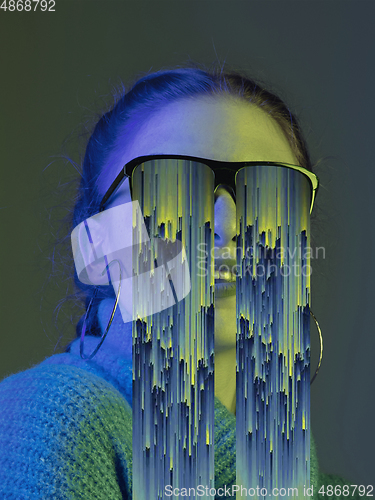 Image of Modern woman\'s portrait on studio background in bright neon light, stylish creative design