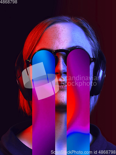 Image of Modern woman\'s portrait on studio background in bright neon light, stylish creative design