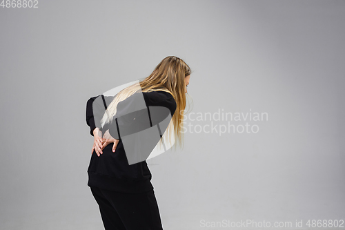 Image of Young woman suffers from pain, feels sick, ill and weakness isolted on studio background