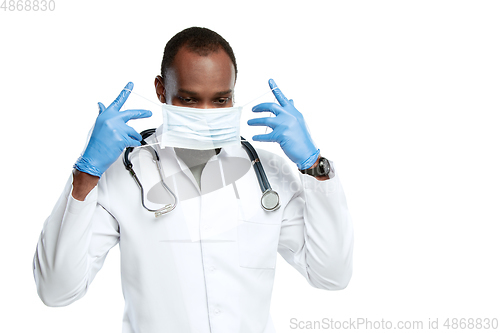 Image of Male young doctor with stethoscope and face mask isolated on white studio background