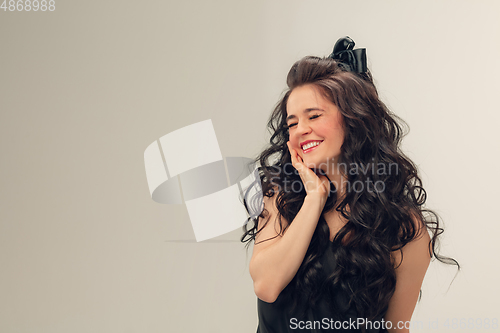 Image of Portrait of beautiful young woman isolated on grey studio background