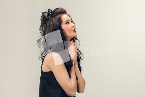 Image of Portrait of beautiful young woman isolated on grey studio background