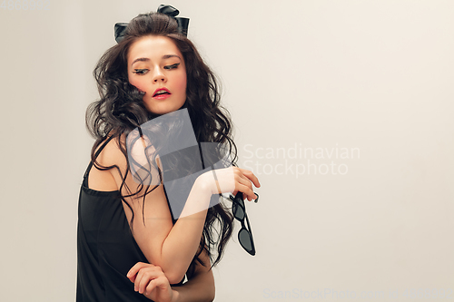 Image of Portrait of beautiful young woman isolated on grey studio background