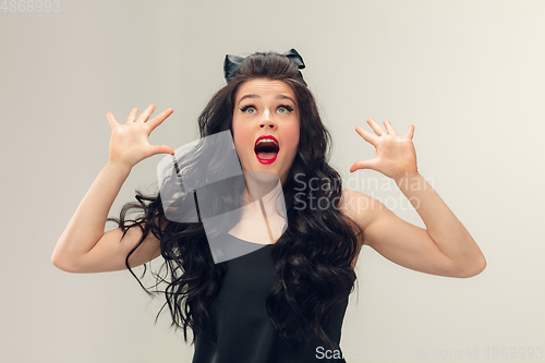 Image of Portrait of beautiful young woman isolated on grey studio background