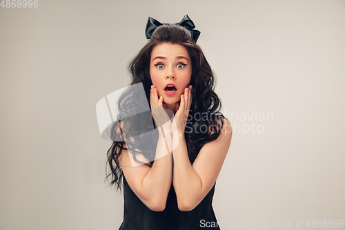 Image of Portrait of beautiful young woman isolated on grey studio background