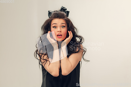 Image of Portrait of beautiful young woman isolated on grey studio background