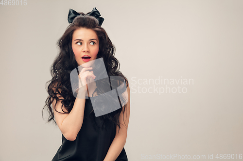 Image of Portrait of beautiful young woman isolated on grey studio background