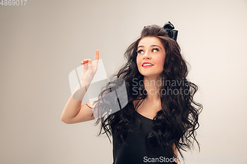 Image of Portrait of beautiful young woman isolated on grey studio background