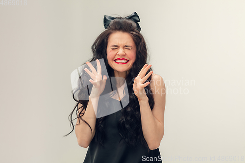 Image of Portrait of beautiful young woman isolated on grey studio background