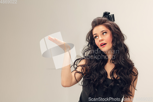 Image of Portrait of beautiful young woman isolated on grey studio background