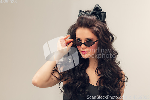 Image of Portrait of beautiful young woman isolated on grey studio background