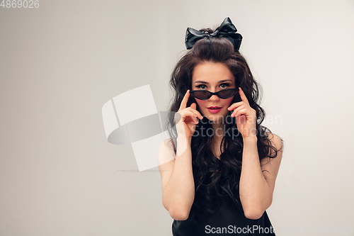Image of Portrait of beautiful young woman isolated on grey studio background