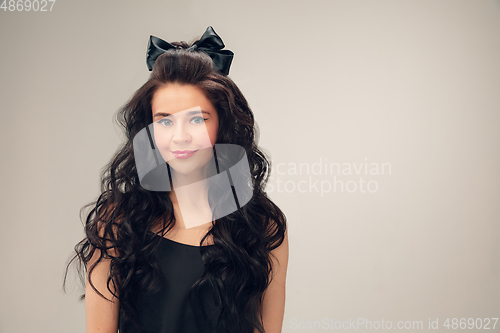 Image of Portrait of beautiful young woman isolated on grey studio background