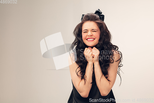 Image of Portrait of beautiful young woman isolated on grey studio background