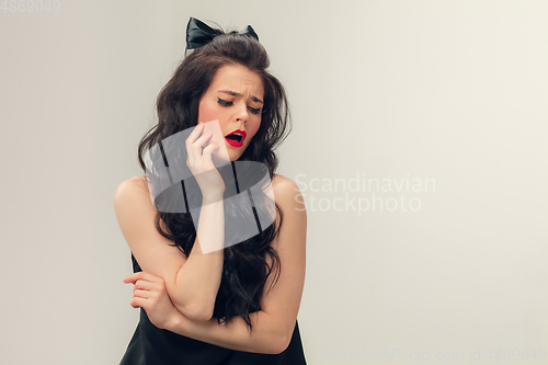 Image of Portrait of beautiful young woman isolated on grey studio background