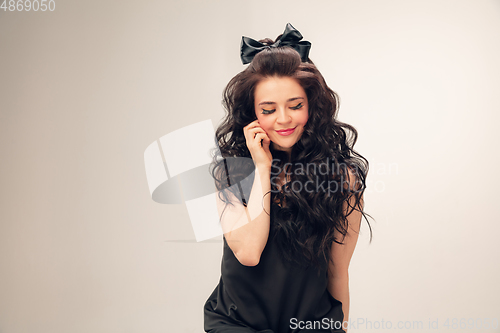 Image of Portrait of beautiful young woman isolated on grey studio background