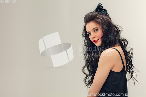 Image of Portrait of beautiful young woman isolated on grey studio background