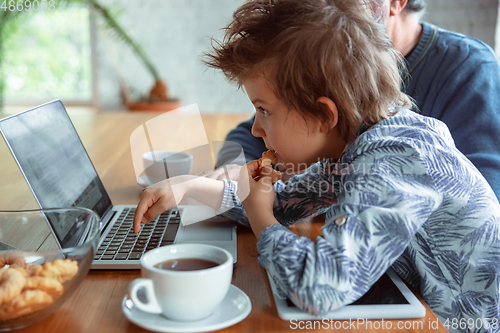 Image of Grandfather and his grandson spending time insulated at home, stadying, watching cinema, shopping together