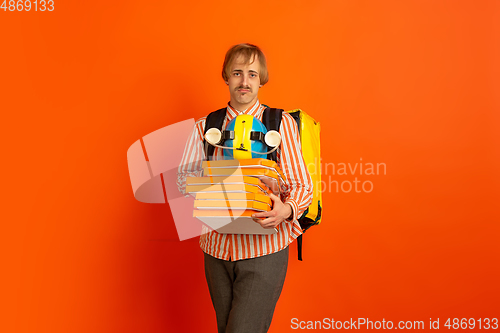 Image of Contacless delivery service during quarantine. Man delivers food and shopping bags during insulation. Emotions of deliveryman isolated on orange background.