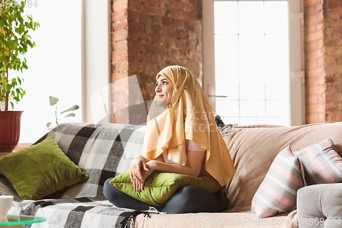 Image of A pretty young muslim woman at home during quarantine and self-insulation