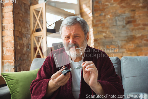 Image of Mature senior older man during quarantine, realizing how important stay at home during virus outbreak, suffers of glaucoma, eye deseases